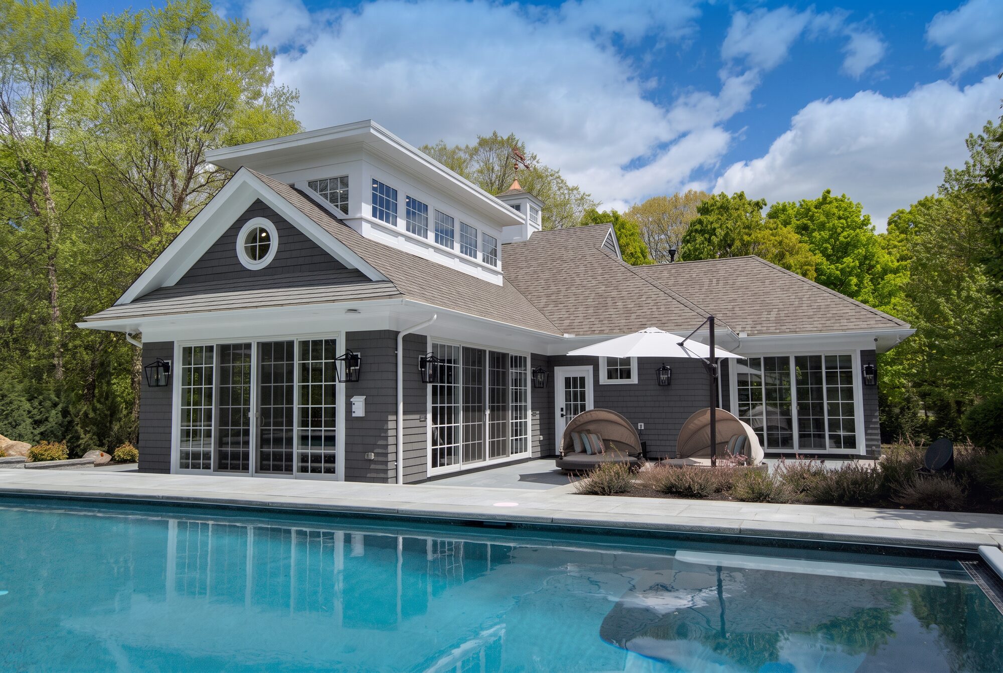 grey cottage behind a still pool, delivered